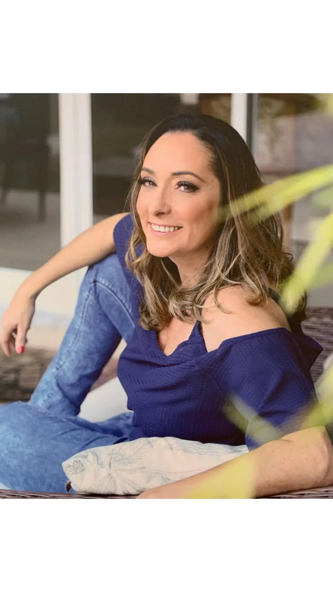 Dra. Sabrina Nunes sorrindo em um retrato descontraído, de blusa azul.