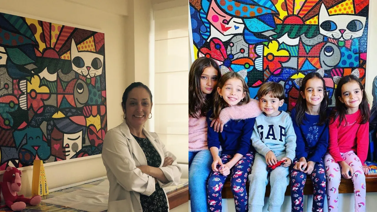 Dra. Sabrina Nunes no consultório ao lado de um quadro colorido e um grupo de crianças sentadas em frente ao mesmo quadro.